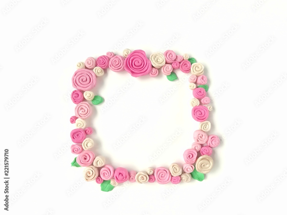 Sweet pink tone rose flower handmade from plasticine clay arrange as a frame are beautiful on white background, cute floral dough