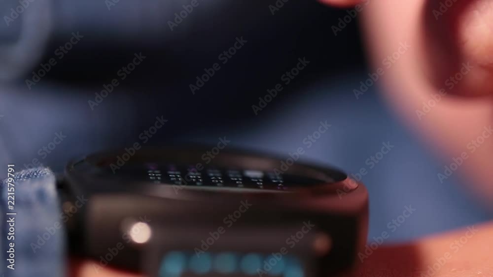 Close-up view of white kid's hand with black smartwatch. Child learning to use his new modern gadget with touch screen. Shallow depth of field. Real time full hd video footage.