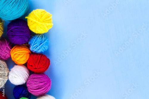 Knitting threads on a blue background. Copy space. Top view