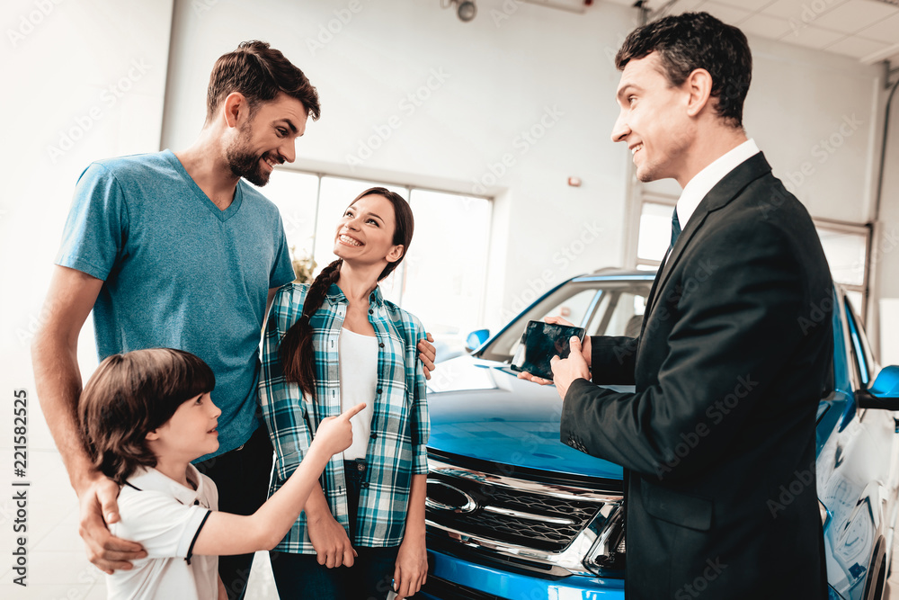 Obraz premium Young Family Are Choosing A New Car In Showroom.