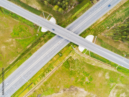 Aerial view of highway in city. Cars crossing interchange overpass. Highway interchange with traffic. Aerial bird's eye photo of highway. Expressway. Road junctions. Car passing. Top view from above.