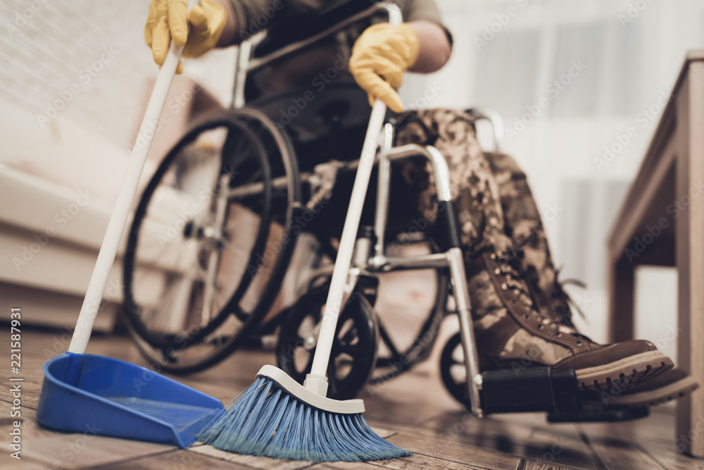 Female Veteran In A Wheelchair Is Cleaning House.