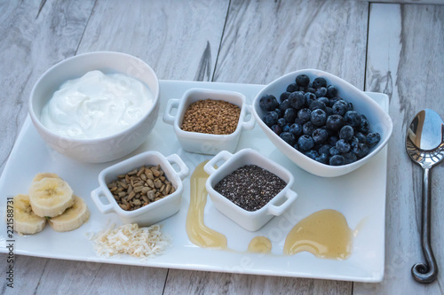Fototapeta Naklejka Na Ścianę i Meble -  Healthy Breakfast Choice Ingredients-Greek Yogurt with fruit, flax seeds, sunflower seeds, chia seeds and honey