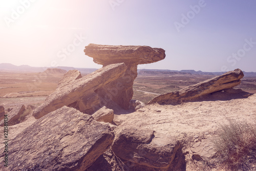Spain, Bardenas Reales: Sunshine over famous Spanish natural semi desert sierra natural preserve park with Pisquerra rocky mountain chain, wide plains and blue sky - panorama in nostalgic look. photo