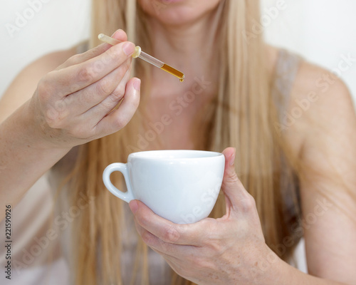 middle age woman real portrait bed bedroom blonde long hair fifty plus copy space 50 blanket pillow face glasses cup drops pipette