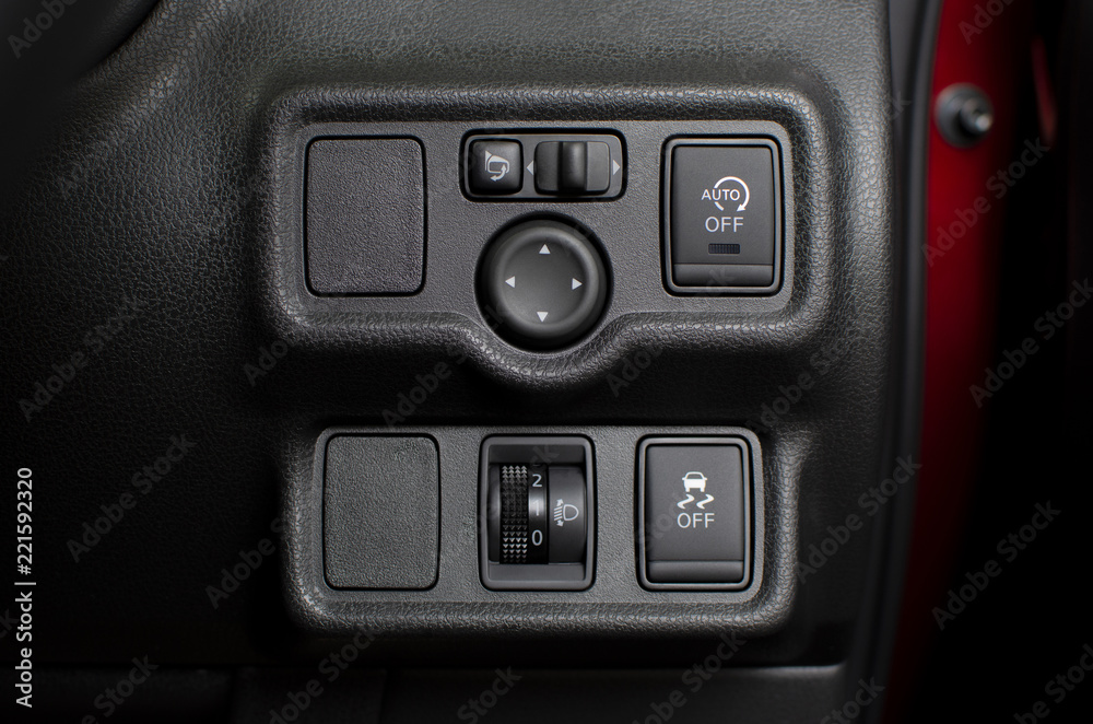 Button panel in car with headlight level switch and traction control and idling stop and wing mirror control switch, automotive part concept. Button panel in car with headlight level switch and traction control and idling stop and wing mirror control switch, automotive part concept.