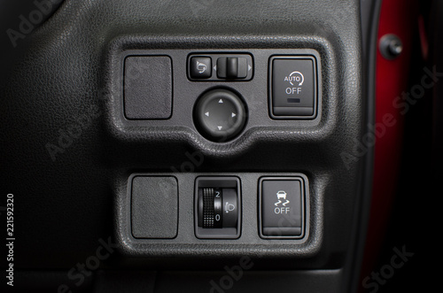 Button panel in car with headlight level switch and traction control and idling stop and wing mirror control switch, automotive part concept. © BLKstudio