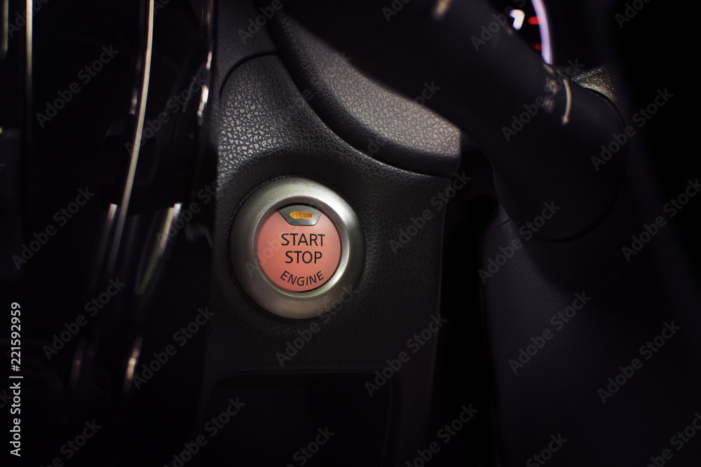 Engine start button of car with a orange light, automotive part concept.
