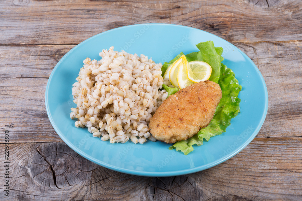 Pearl barley porridge served with fish cutlet Pearl barley porridge served with fish cutlet