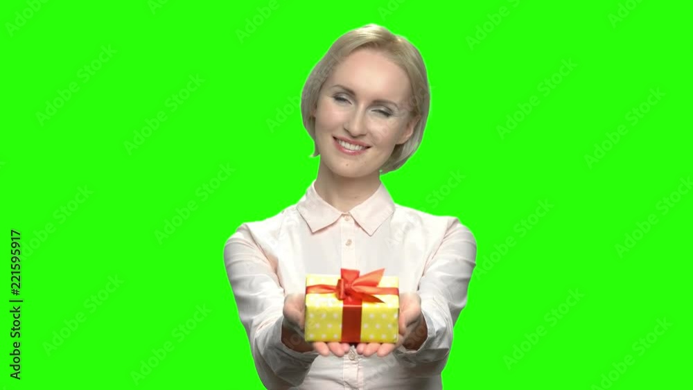 Portrait of caucasian woman giving gift box. Blond mature business woman. Green hromakey background for keying. Portrait of caucasian woman giving gift box. Blond mature business woman. Green hromakey background for keying.