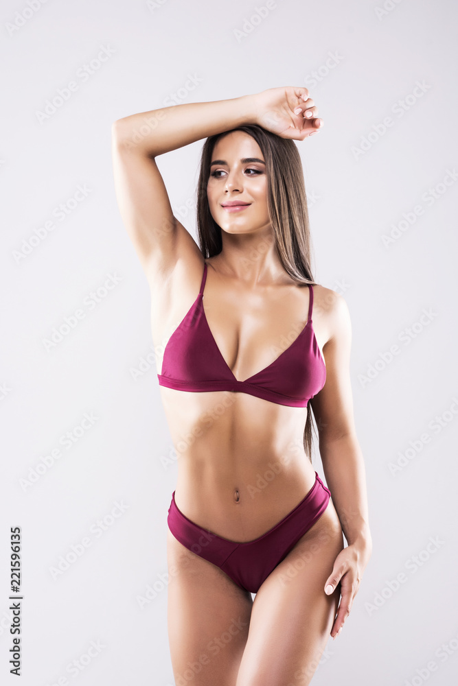 Young woman with beautiful slim perfect body in bikini isolated white background Young woman with beautiful slim perfect body in bikini isolated white background