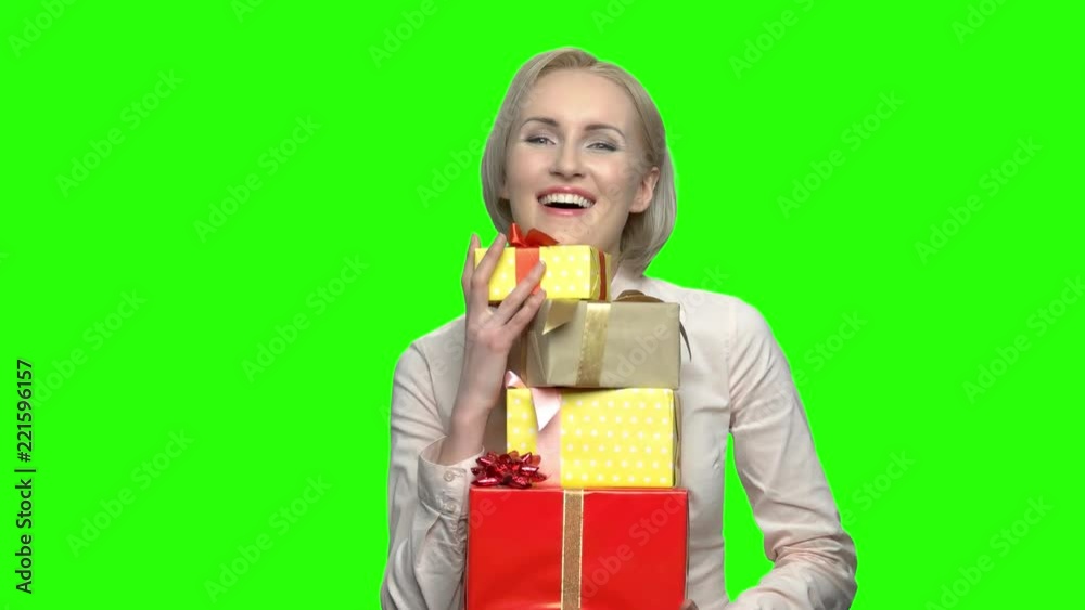 Mature woman recieved many gift boxes for her birthday. Green hromakey background for keying. Mature woman recieved many gift boxes for her birthday. Green hromakey background for keying.