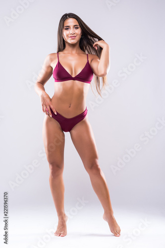 Young sporty sexy woman with perfect fit body in sexy bikini against white background