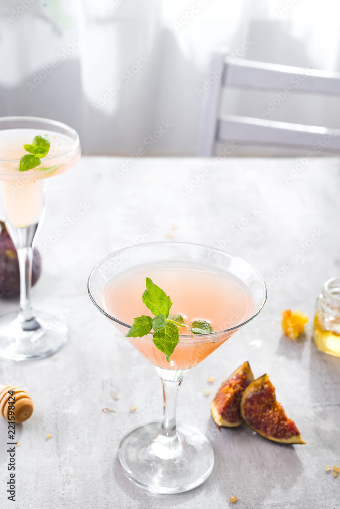 Jack Rose Cocktail with figs and honey on light background over windows, flat lay with copy space