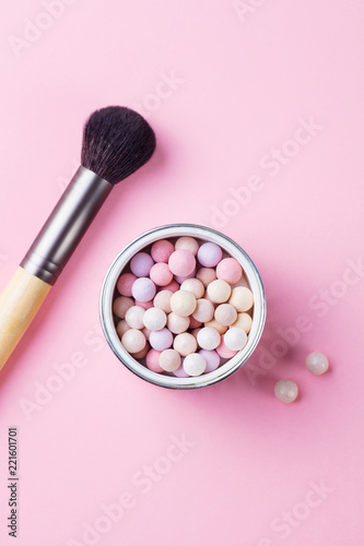 Pearl make up powder on pink pastel background. Top view.