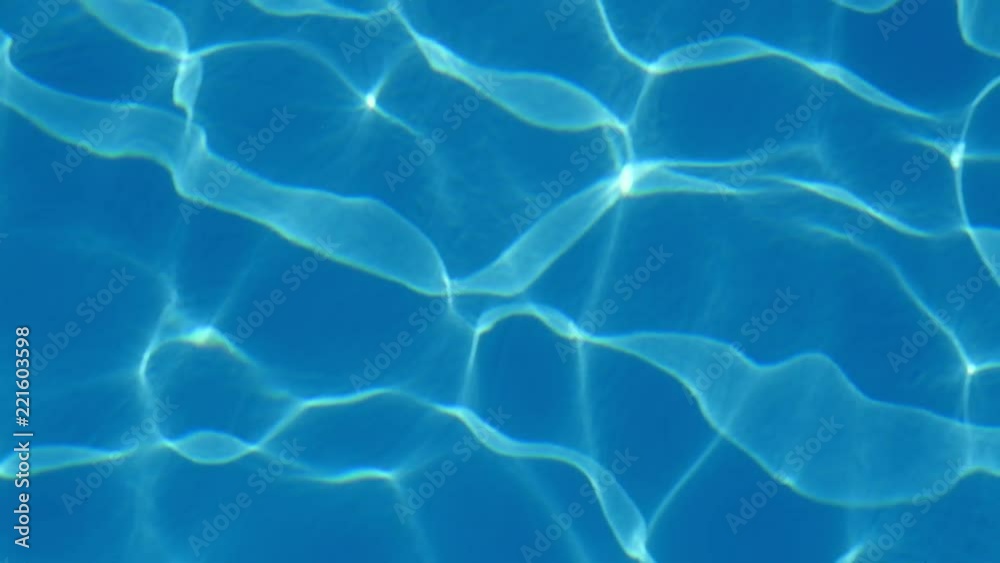 A mesmerizing view of swinging light blue waters in a see-through paddling pool with altering stripes forming a cheery background. A mesmerizing view of swinging light blue waters in a see-through paddling pool with altering stripes forming a cheery background.