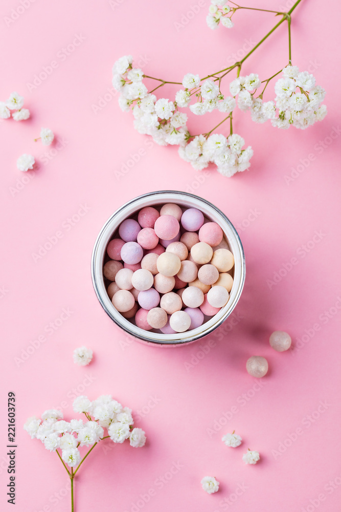 Pearl make up powder on pink pastel background. Top view.