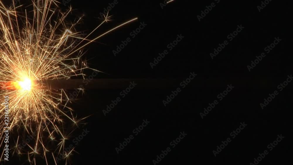 Close up of a single sparkler burning horizontally through the middel of the frame. Close up of a single sparkler burning horizontally through the middel of the frame.