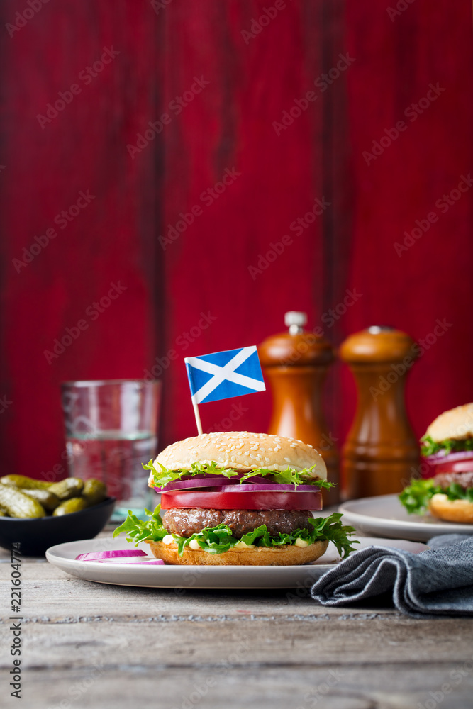 Burger on a plate with pickles. Wooden background. Copy space. Burger on a plate with pickles. Wooden background. Copy space.
