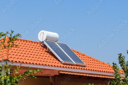Solar water heating panel and water collector on a house roof.