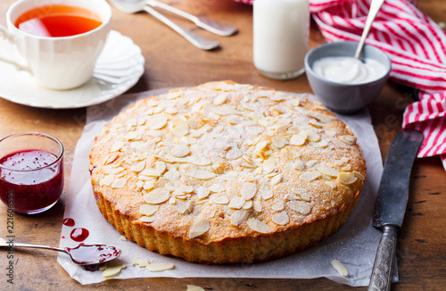 Almond and raspberry cake, Bakewell tart. Traditional British pastry. Wooden background. photo