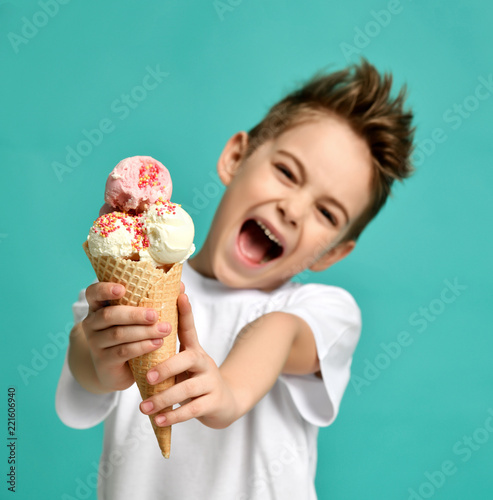 Obraz na płótnie Baby boy kid hold strawberry vanilla ice cream in waffles cone happy smiling screaming yelling on blue mint background w salonie