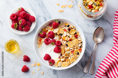 Healthy breakfast. Fresh granola, muesli with yogurt and berries on marble background. Top view.