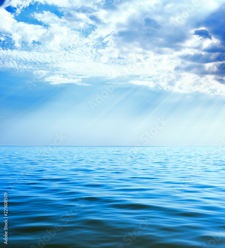 clouds with rays over blue sea