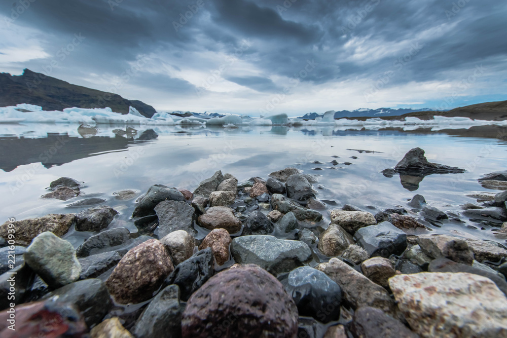 Eisberge schwimmend vor Steinen Island