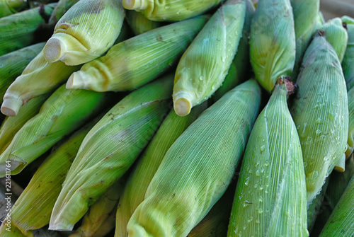 A stack of corn in an open air market.