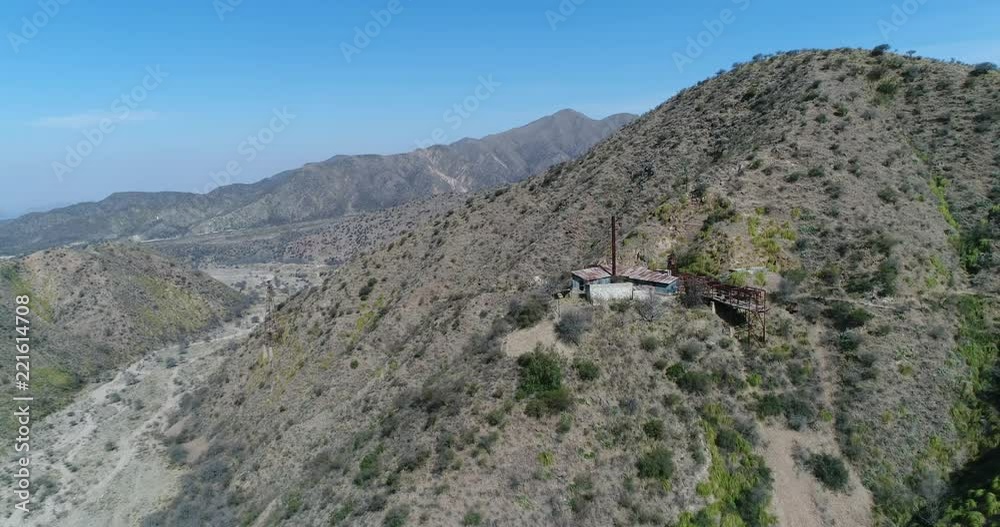 Aerial drone scene. Third Station of Cable Car Chilecito - La Mejicana gold mine. General view of construction and towers of cable car. Camera moves away ascending. Mountains at background Aerial drone scene. Third Station of Cable Car Chilecito - La Mejicana gold mine. General view of construction and towers of cable car. Camera moves away ascending. Mountains at background