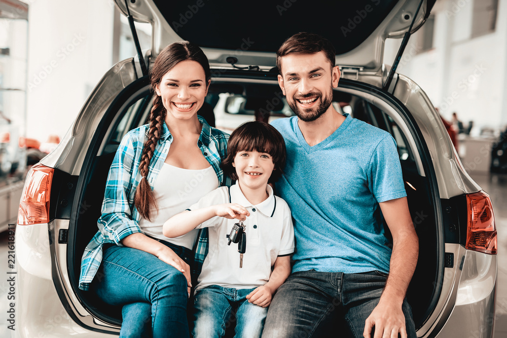 Family Are Sitting In The Trunk Of A New Car.