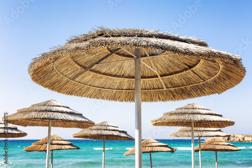 Fototapeta Naklejka Na Ścianę i Meble -  Caps of umbrella beach umbrellas, turquoise sea, blue sky