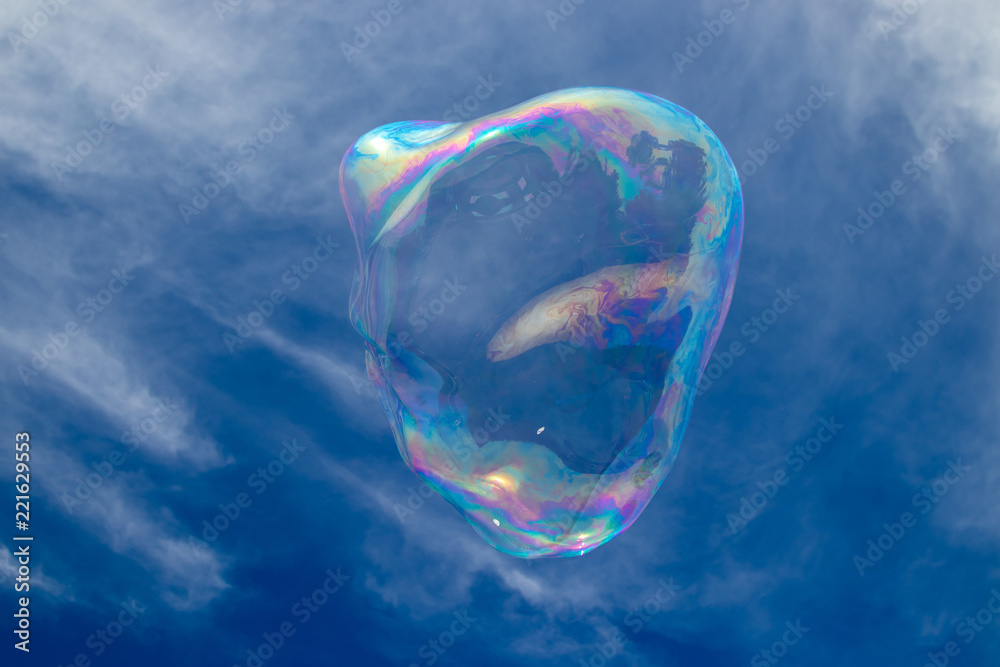 Giant colourful bubble with light clouds and blue sky, no people, family fun, summer.