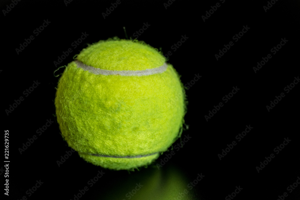 fuzzy green tennis ball on black background