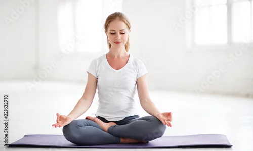 Obraz kobieta praktykująca jogę i medytująca w pozycji lotosu