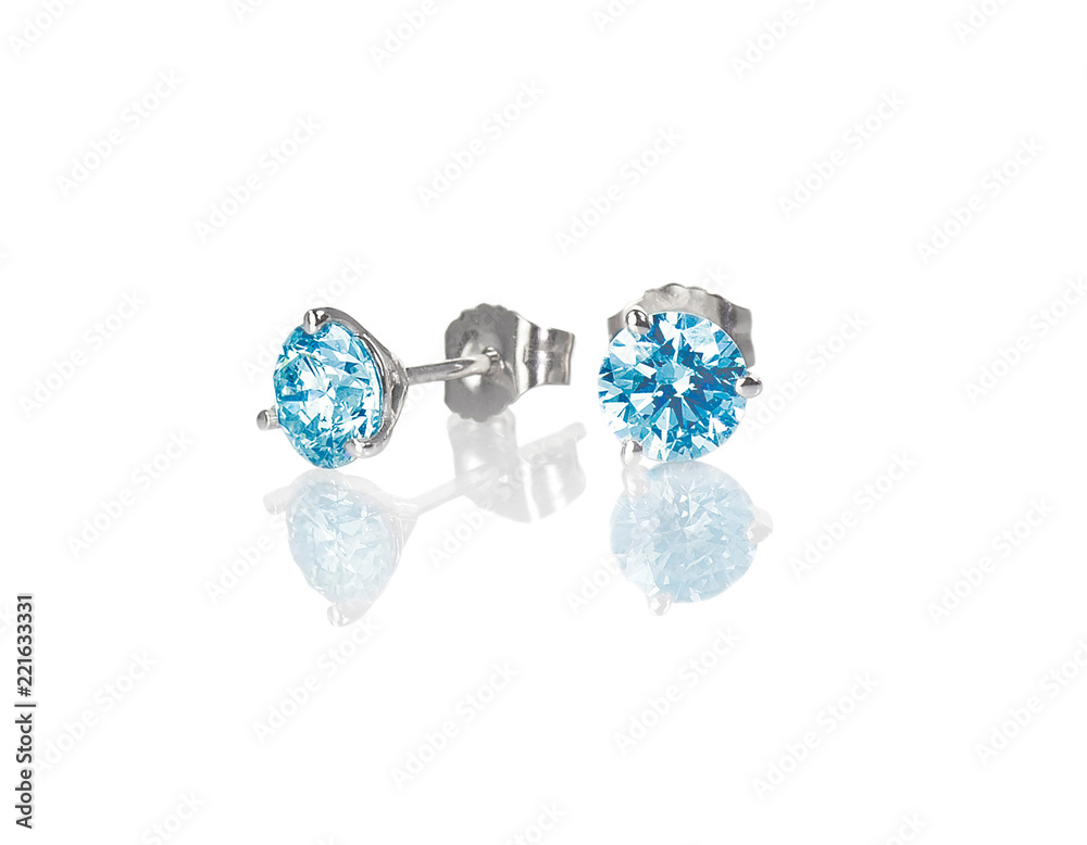 Blue diamond stud earrings topaz round brilliant isolated on white with a reflection Blue diamond stud earrings topaz round brilliant isolated on white with a reflection