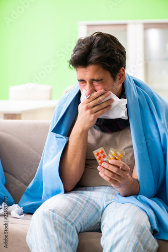 Sick young man suffering from flu at home