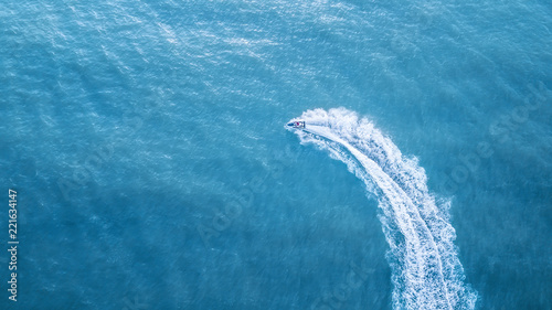 Scooter at the sea surface. Aerial view of luxury floating boat on transparent turquoise water at sunny day. Summer seascape from air. Top view from drone. Seascape with motorboat in bay. 