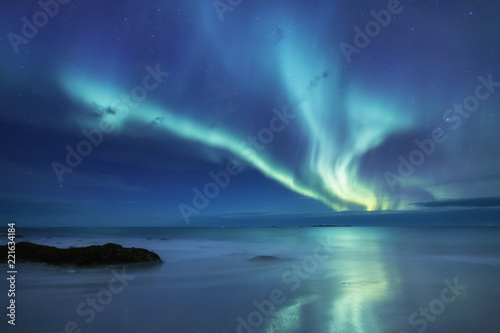Aurora borealis on the Lofoten islands, Norway. Green northern lights above ocean. Night sky with polar lights. Night winter landscape with aurora and reflection on the water surface.  © biletskiyevgeniy.com