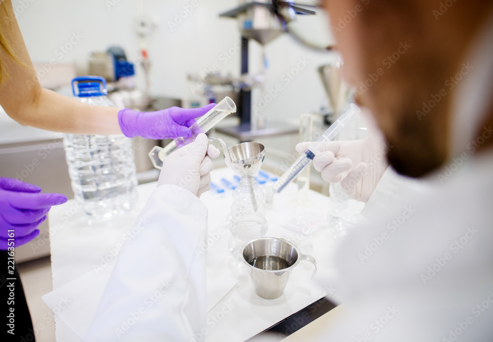 Fototapeta premium Young man in protective wear taking samples of products and preparing them for exam.
