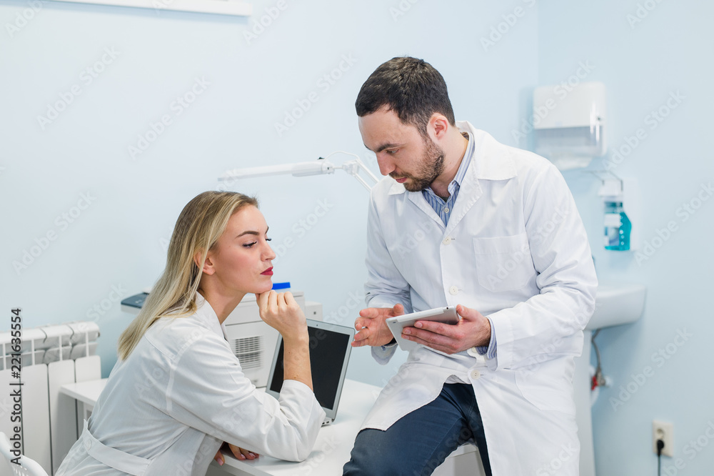 Doctor and nurse student working with a tablet isolated on a white background Doctor and nurse student working with a tablet isolated on a white background