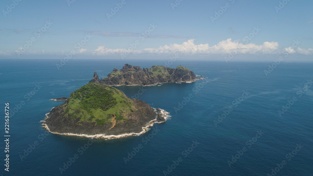 Small rocky islands in the sea, blue sky and clouds. Dos Hermanas, Palau, Santa Ana. Aerial view of seascape with tropical islands in the ocean.