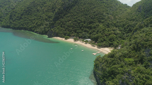 Aerial view coastline with beach and mountains covered with tropical forest in province Caramoan, Philippines. Landscape with sea, mountains and beach.