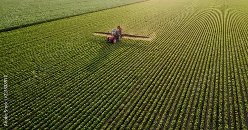 Aerial drone shot of a farmer spraying soybean fields