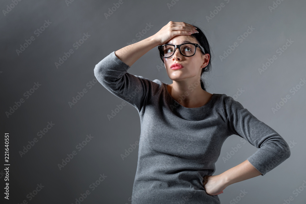 Young woman making a mistake on a solid background