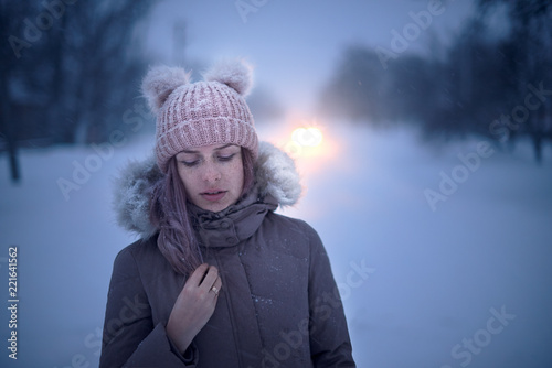 Beautiful young girl at the winter backgroung in village
