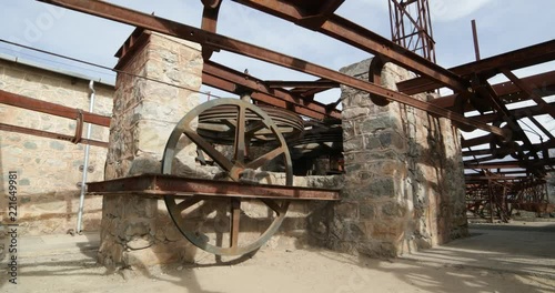 Second station of old Cable Car Chilecito-La Mejicana mine. Camera rotates and moves sideways showing wheels which made the system move, rails and rusty wagons at background. National heritage photo