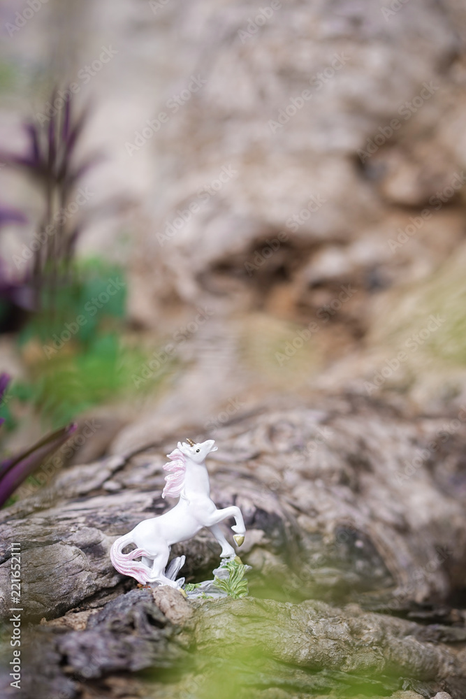 Unicorn. A miniature of a white bucking horse unicorn in the forest. A magical and fairytales concept. Selective focus on the unicorn eye. Unicorn. A miniature of a white bucking horse unicorn in the forest. A magical and fairytales concept. Selective focus on the unicorn eye.