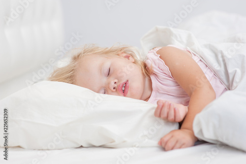 little baby girl sleeping on a bed